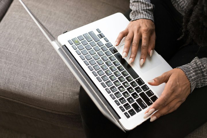 Person holding a smartphone with a router in the background.